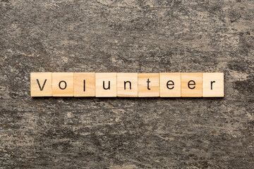 volunteer word written on wood block. volunteer text on table, concept.