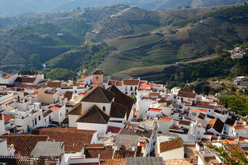 Fototapeta premium Aerial view of the village Frigiliana, Axarquia, Malaga province, Andalusia, Spain, with the green and cultivated countryside in the background and the church San Antonio de Padua