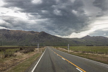road with yellow line and storm clouds in New Zealand