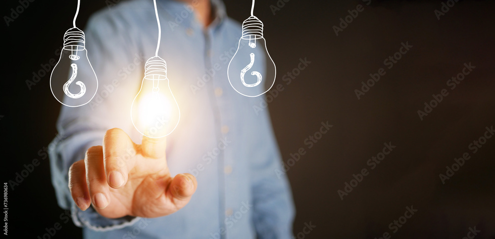 Aufkleber idea concept. hand touches illuminated light bulb with two others with question marks. lightblub is 