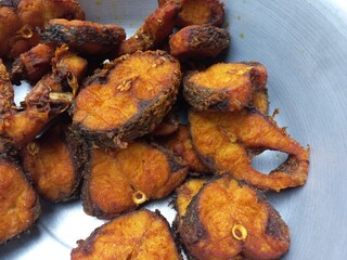 Dry tarmerik salt masala fish fry is a simple tasty delicious and flavourful fish fry in Aluminum pot,Hot Fried Fish on a Almuniyam container with Hot Oil,Hot bubbly and so delicious Fish,brown Fish 