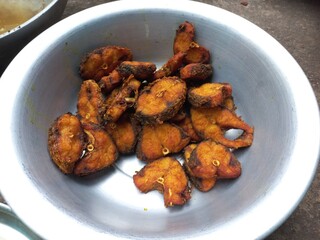 Dry tarmerik salt masala fish fry is a simple tasty delicious and flavourful fish fry in Aluminum pot,Hot Fried Fish on a Almuniyam container with Hot Oil,Hot bubbly and so delicious Fish,brown Fish 