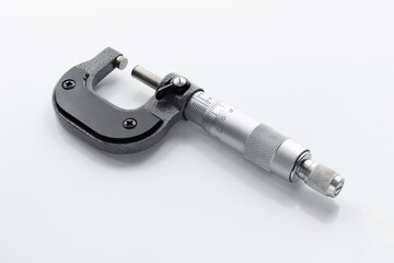 Close-up of a mechanical micrometer on a light background.