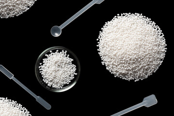 Close-up of laboratory instrument and samples of polymer plastic granules. Isolated on black background.
