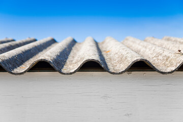 Old aged and damaged dangerous roof made of prefabricated and wave-shaped panels