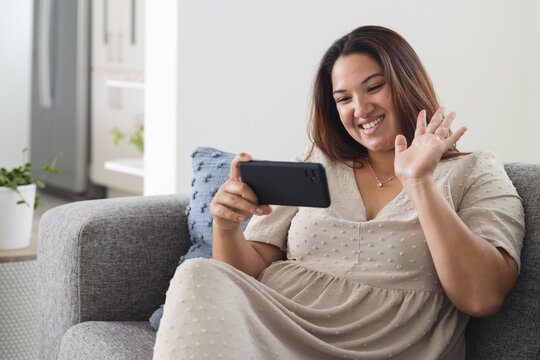 Young plus size biracial woman enjoys a video call at home