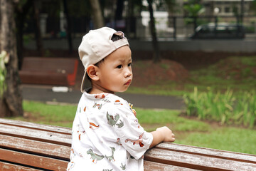 Young boy having fun at the bench of the park