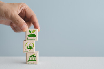 Hand arranged wooden cube blocks with ESG icon and text including copy space. For ESG concept of...