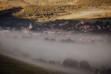 Fototapeta premium Amazing landscape with Rimetea village covered in fog. Morning