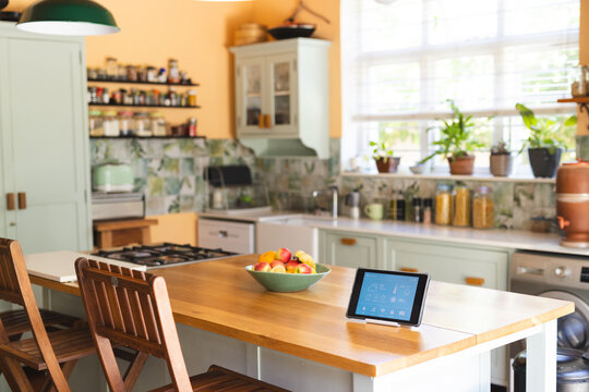 A modern kitchen interior features a smart home tablet