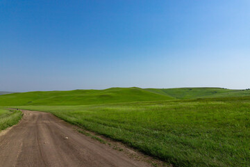 A picturesque view of the green steppe hills, pastures stretching into the distance.