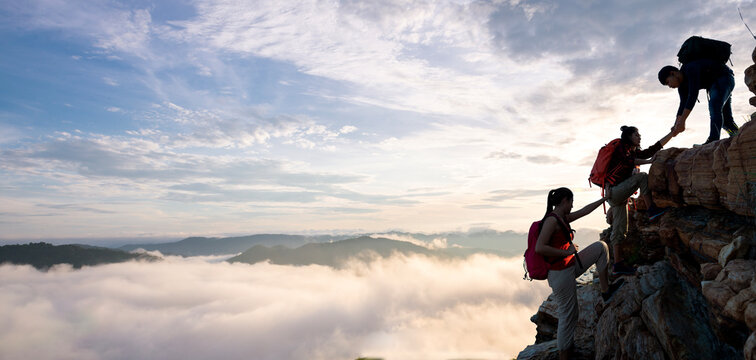 Asian hiking help each other on mountains