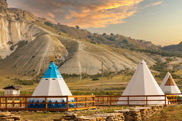 Great view of the tipi in the field with the American rocky mountain landscape in the background.