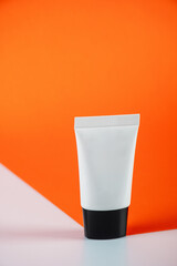 Cosmetic bottles,Plastic white tube for cream or lotion on orange and white background