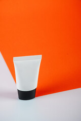 Cosmetic bottles,Plastic white tube for cream or lotion on orange and white background