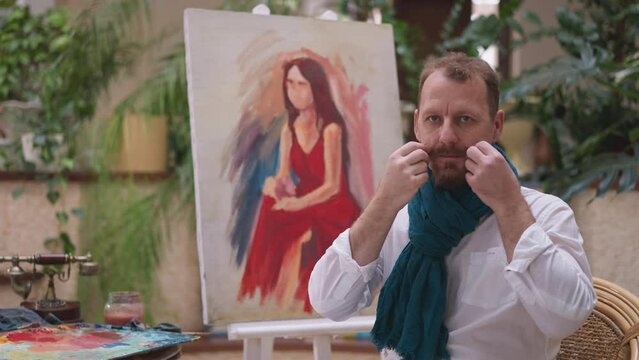Man painter adjusts mustache with care