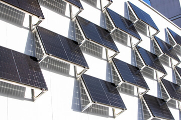 Panneaux solaires installés sur un grand mur blanc en ville