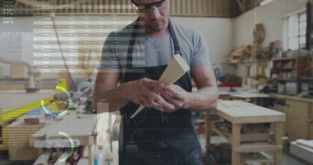 Two men building in a workshop with graphs and stats