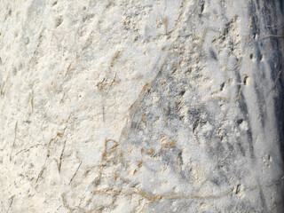 The texture of a gray marble stone with veins, cracks and inclusions