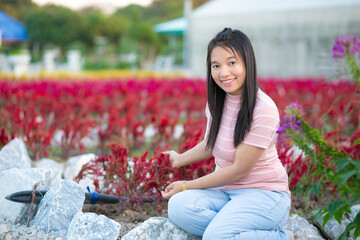 Beautiful asian woman in the flower garden with nature background.