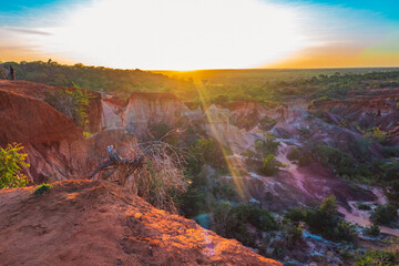 Scenic view of tourists dwarfed by rock formations at Marafa Depression - Hell's Kitchen at sunset in Malindi, Kenya