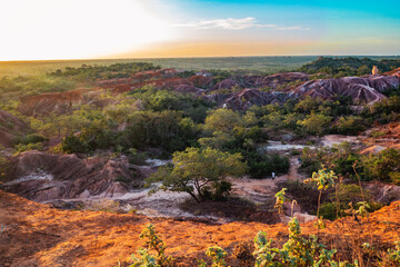 Scenic view of tourists dwarfed by rock formations at Marafa Depression - Hell's Kitchen at sunset...