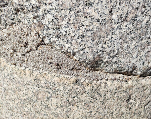The texture of a gray marble stone with veins, cracks and inclusions
