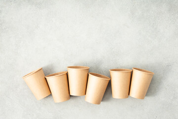 Flat lay composition with eco-friendly paper cups on grey stone background