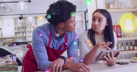 Image of media icons over diverse shop assistant and customer talking