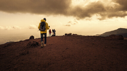 Hikers trekking across the volcanic terrain of Mount Etna - Adventure and exploration in the...