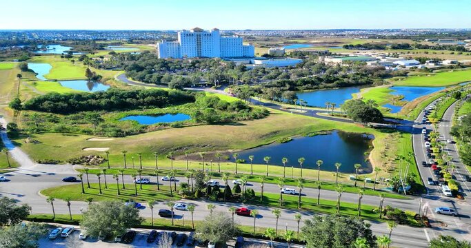Cars driving on road surrounded by greenery and water ponds in Champions Gate, Florida