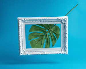 Creative composition made of palm leaf with vintage frame. Minimal summer concept.