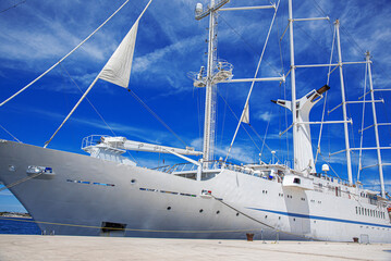 White sailing ship with lowered sails in the port.