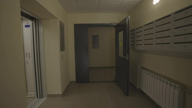 Entrance hall with transparent doors on ground floor in residential building. High-rise block offers modern design solutions for urban residents