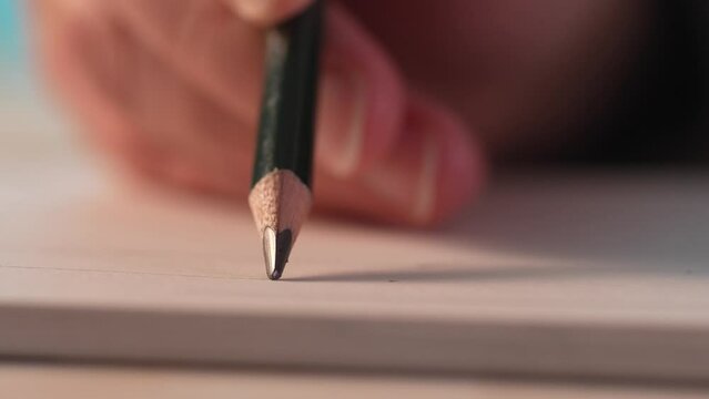 Hand line drawing with a pencil in sketchbook. Close-up, shallow dof.