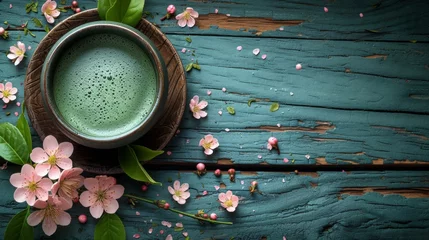 Schilderijen op glas Cup of matcha latte green tea and spring flowers on rustic wooden background © nataliia_ptashka
