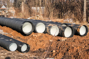 Pipeline laying in the ground. Black plastic pipes