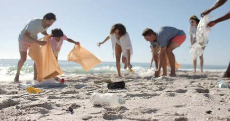 Diverse friends participate in a beach cleanup, with copy space - Powered by Adobe