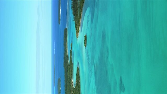 Isle of Pines New Caledonia crystal clear water in a paradise lagoon - vertical aerial flyover