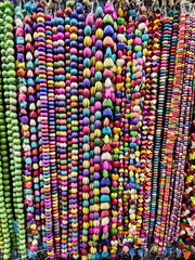 A vibrant and dazzling assortment of beads, cascading down a wall, creating a stunning display of color and texture.