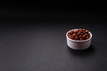 Delicious hazelnut whole, raw, without shell, on a dark concrete background