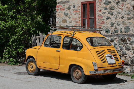 Classical Zastava Z750 LE from 1980, orange-yellow colored, so-called Fikjo car, parked in front of a vernacular house. Vevchani-North Macedonia-347