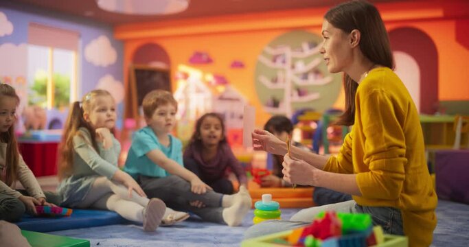 Female Preschool Teacher Playing and Creatively Studying with Multiethnic Kids in Kindergarten. Small Adorable Children Getting Basic Reading and Writing Skills, Learning Alphabet in a Fun Way