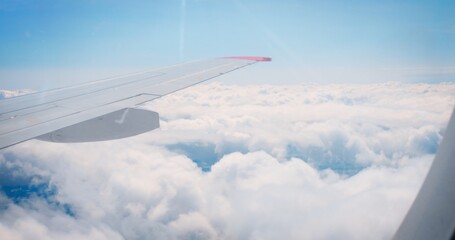 Airplane wing clouds, clear day flight, window view. showcasing aviation technology. skies,...