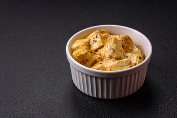 Delicious soft white feta cheese with salt, spices and herbs on a dark concrete background