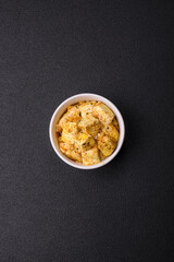 Delicious soft white feta cheese with salt, spices and herbs on a dark concrete background