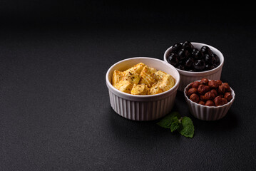 Delicious soft white feta cheese with salt, spices and herbs on a dark concrete background