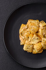 Delicious soft white feta cheese with salt, spices and herbs on a dark concrete background