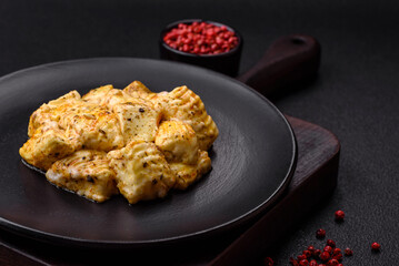 Delicious soft white feta cheese with salt, spices and herbs on a dark concrete background