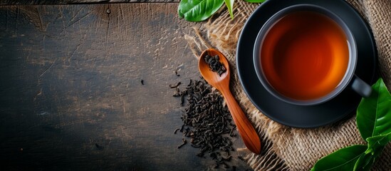 A wooden table set with a cup of tea, tea leaves, and a wooden spoon. The circle of the cup contrasts with the natural elements of wood and plant life - obrazy, fototapety, plakaty